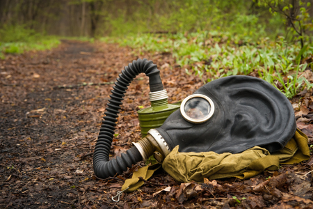 Scary authentic Russian gas mask with breathing hose abandoned in woodsの写真素材