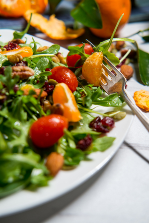 Organic fresh summer clementine salad with nuts and tomatoesの写真素材