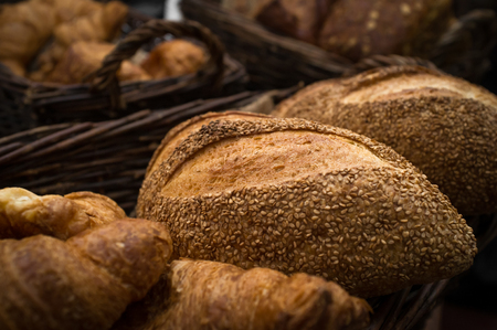 Fresh rustic home made sesame seed loaves of bread on hemp clothの写真素材