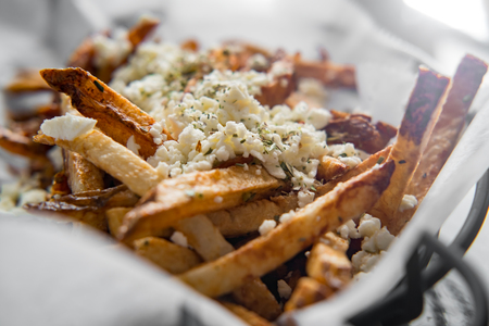 Delicious Mediterranean street cart fried potatoes with feta cheese herbs and spices