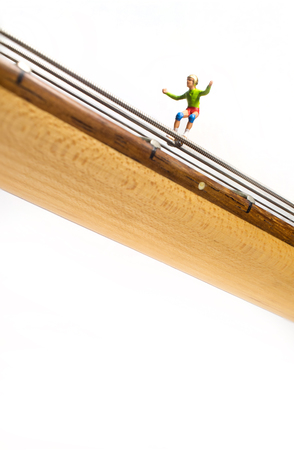 Miniature skateboarding figures grind down guitar strings in macro closeupの写真素材