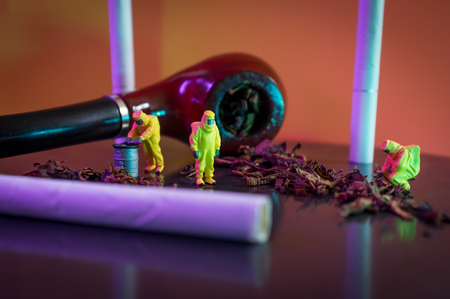 Miniature hazmat team inspects hazardous tobacco productsの写真素材