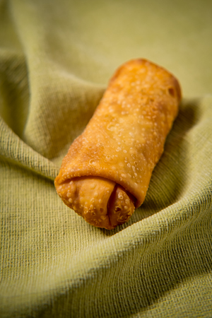 Crispy Chinese fried egg roll on green cloth napkin