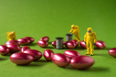 Miniature hazmat team inspects hazardous pain killer pillsの写真素材