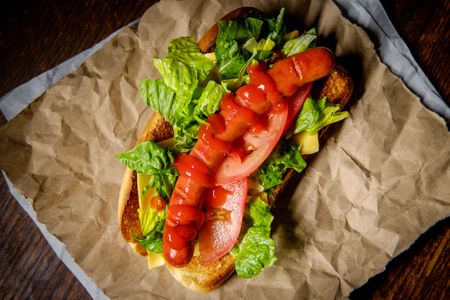 Fancy grilled hotdog with lettuce tomato American cheese and ketchupの写真素材