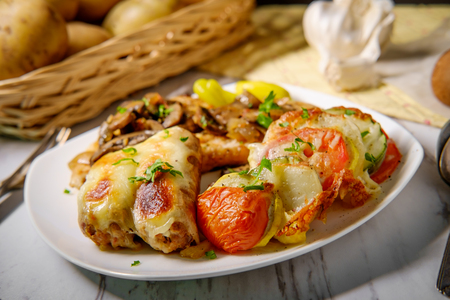 Italian chicken marsala with French vegetable tian and stuffed sausageの写真素材