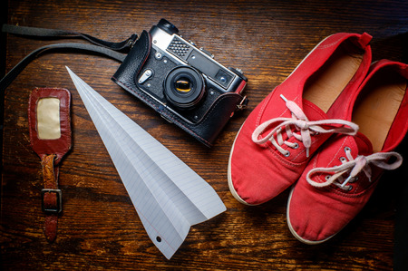 Photography and travel background still life with camera paper airplane and shoes