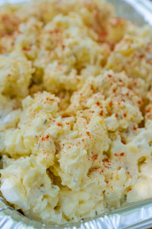 Creamy potato salad loaded with mayonnaise and paprikaの写真素材