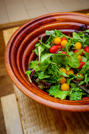 Fresh organic spring mix salad with red and yellow grape tomatoesの写真素材