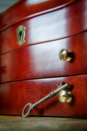 Old antique skeleton key on distressed textured wooden backgroundの写真素材
