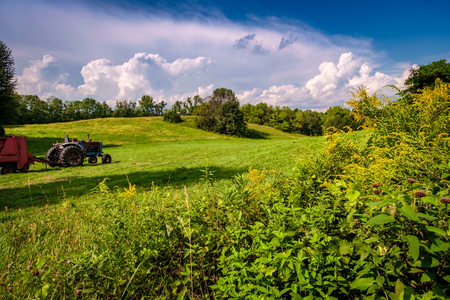 Tractor with large tires on farmland hills summer timeの写真素材