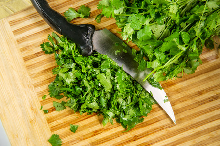 Kitchen cutting board slicing fresh green cilantroの写真素材