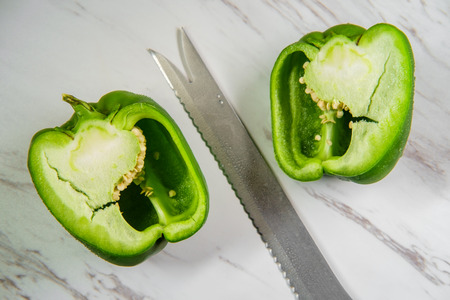 Green bell pepper sliced in half showing seeds and pithの写真素材
