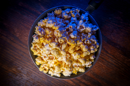 Movie theater popcorn with butter and blue backlightingの写真素材