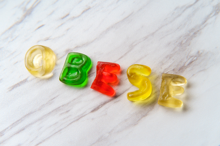 Assorted colorful gummy candy letters spell the word Obeseの写真素材