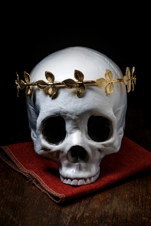 Human skeleton skull of King or Queen wearing royal gold leaf crownの写真素材