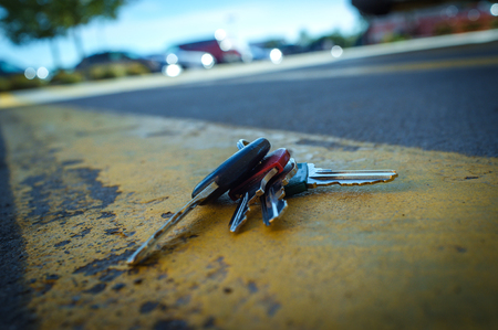 Lost car keys on distressed road painted yellow linesの写真素材
