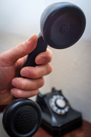 Old vintage rotary dial telephone on wooden deskの写真素材