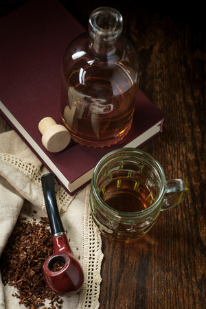 Leisure tobacco pipe and whisky with bottle and a good mystery bookの写真素材