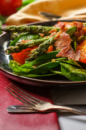 Prosciutto asparagus salad with roasted tomatoes spinach leaves and balsamic vinaigretteの写真素材