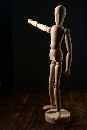 Wooden articulated artist doll pointing towards copy spaceの写真素材