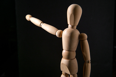 Wooden articulated artist doll pointing towards copy spaceの写真素材