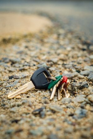 Rainy day lost car keys in wet parking lot pavement