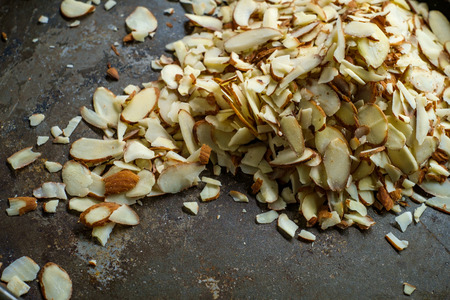 Shelled and sliced almonds for baking on wooden table with dark moody lightingの写真素材
