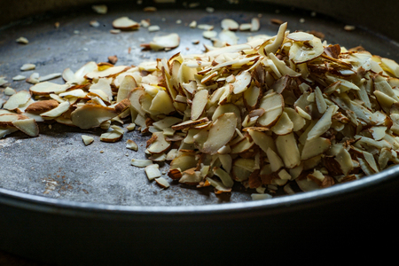 Shelled and sliced almonds for baking on wooden table with dark moody lightingの写真素材