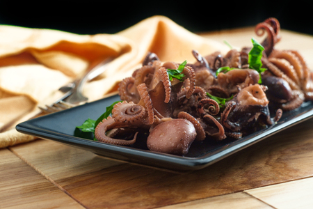 Boiled baby octopus served with olive oil and parsleyの写真素材