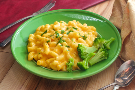 Delicious macaroni and cheddar cheese with steamed broccoliの写真素材