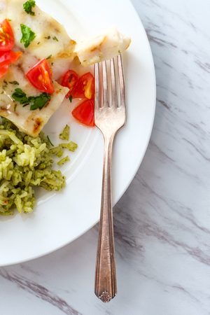 Grilled Alaskan Pollock fish fillets with lemon butter and green rice