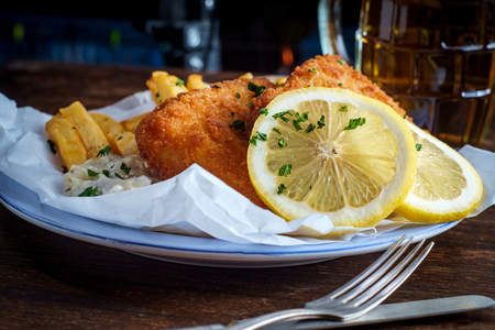 Authentic traditional British cuisine fish and chips served with an ice cold beerの写真素材