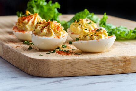 Stuffed Russian deviled eggs topped with parsley and paprikaの写真素材