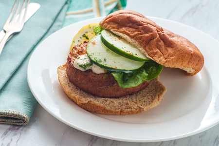 Seasoned fish cake sandwich on a whole wheat hamburger bun with creamy tartar sauceの写真素材