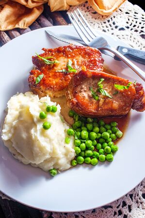 Honey jam glazed BBQ Pork chops with mashed potatoes and green peasの写真素材
