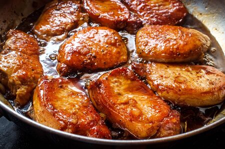 Honey jam glazed BBQ Pork chops frying in large panの写真素材