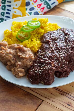Mexican mole poblano chicken with rice and refried pinto beansの写真素材