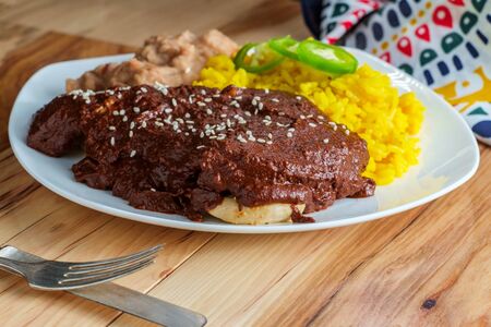 Mexican mole poblano chicken with rice and refried pinto beansの写真素材