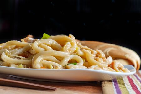 Pan fried Japanese udon noodles in garlic sauce with chickenの写真素材