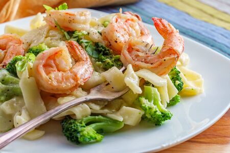 Authentic Italian fettuccine alfredo pasta dish with grilled shrimp and broccoliの写真素材