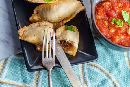 Mexican beef empanadas with tortilla chips and corn salsaの写真素材