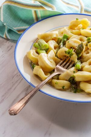 Italian butter and parmesan cheese tortellini alfredo with asparagusの写真素材
