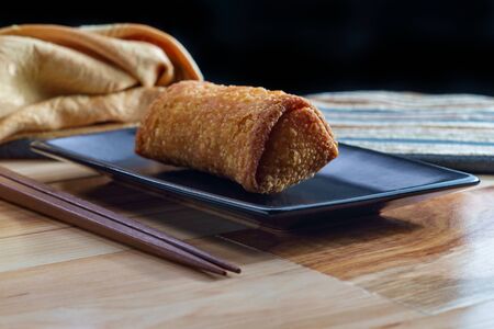 Crispy Chinese fried egg roll on wooden tableの写真素材