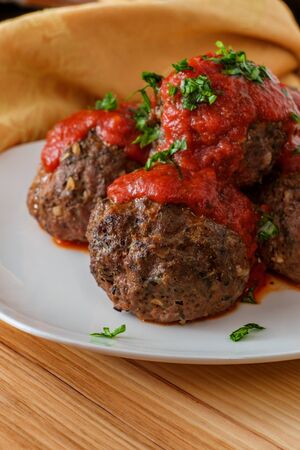 Large Italian meatballs with marinara sauce and parsley garnishの写真素材