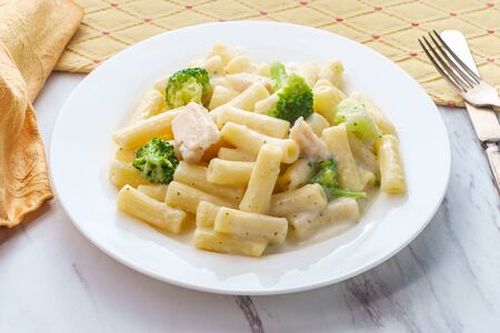 Italian rigatoni chicken alfredo pasta dish with broccoliの写真素材