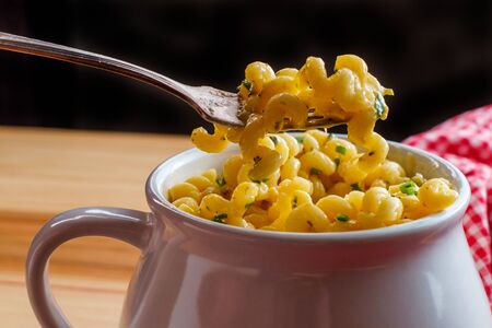 Delicious macaroni and cheddar cheese cellentani pasta in a bowl
