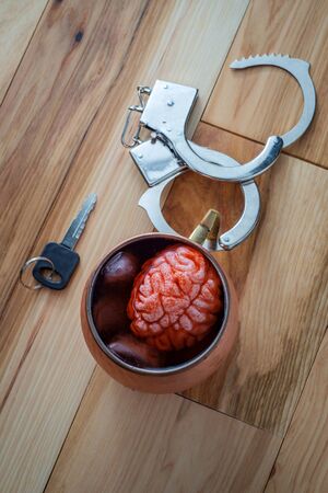 Human brain in copper Moscow mule cocktail mug soaking with car keys and handcuffs for alcoholism...