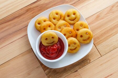 Happy French fried potato smiley faces with ketchupの写真素材