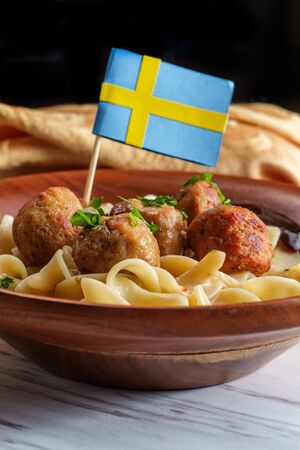 Swedish meatballs with mini flag toothpick noodles gravy and jelly in wooden bowlの写真素材